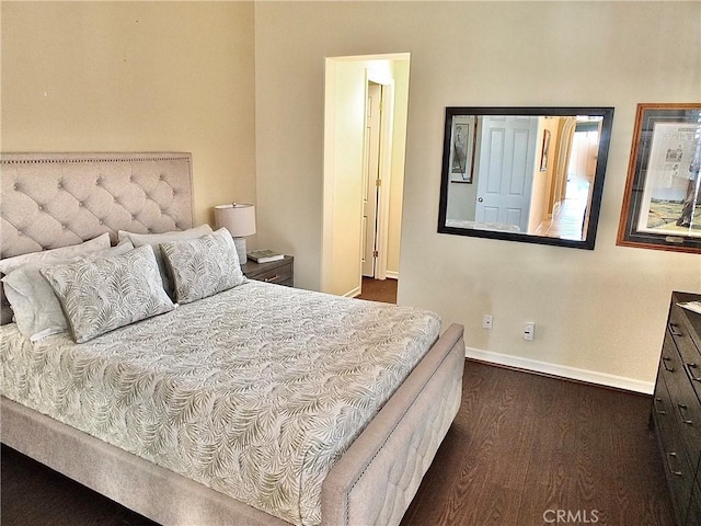 bedroom with dark hardwood / wood-style flooring