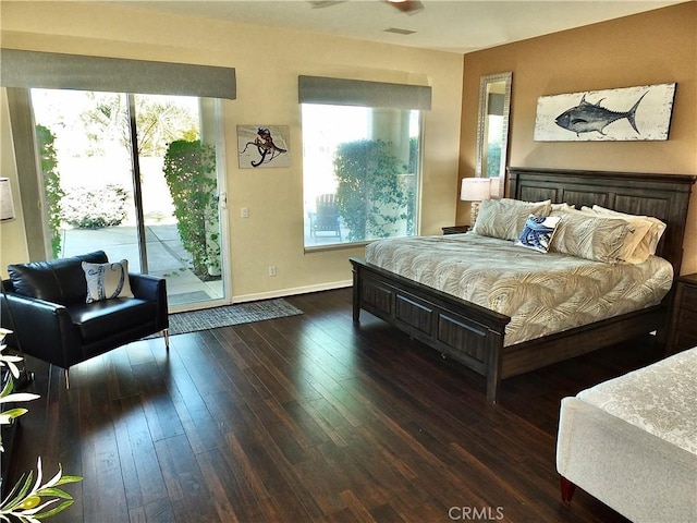 bedroom featuring ceiling fan, multiple windows, dark hardwood / wood-style flooring, and access to outside