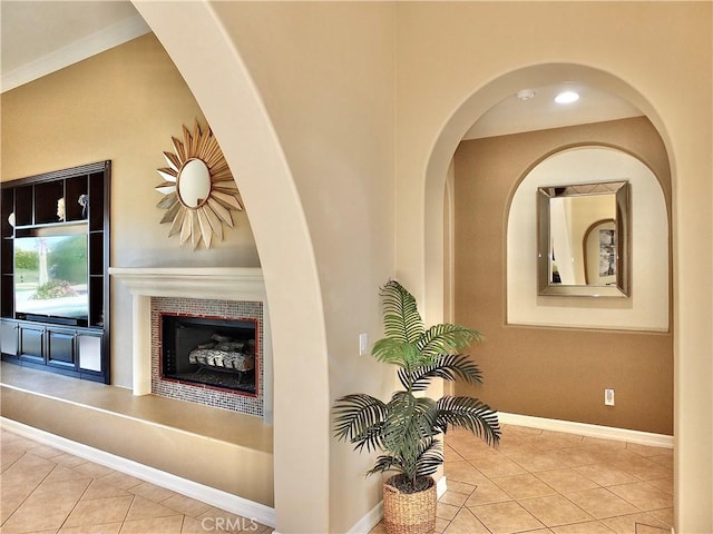 corridor featuring light tile patterned floors and crown molding