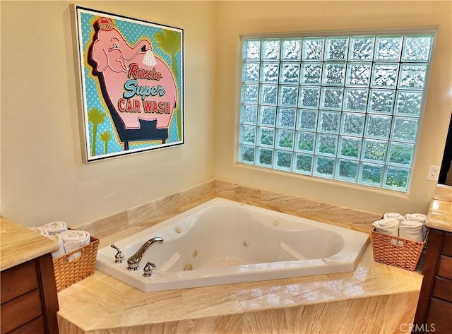 bathroom with vanity and tiled tub