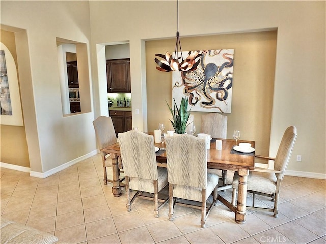 tiled dining area featuring a chandelier