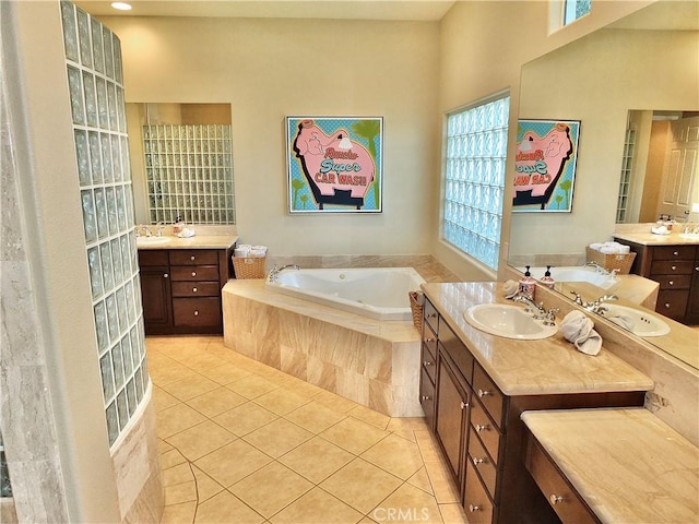 bathroom with a relaxing tiled tub, tile patterned floors, and vanity