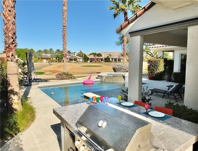 view of pool with a patio area, an outdoor kitchen, and grilling area