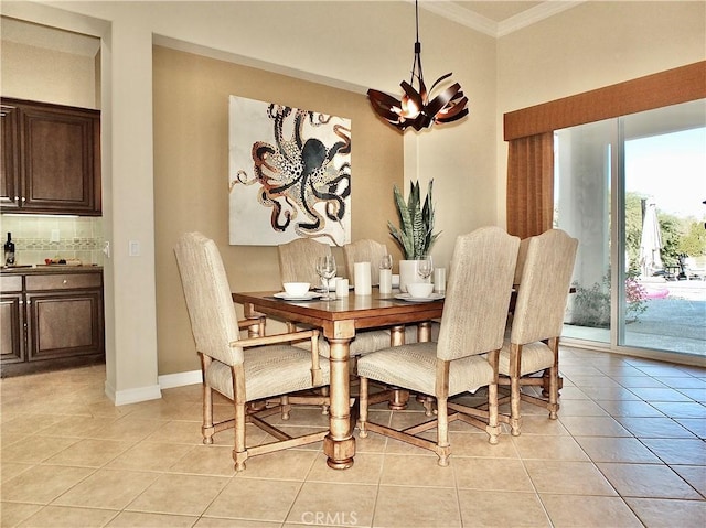 tiled dining area with ornamental molding and a chandelier