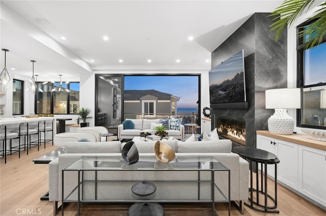 living room featuring light wood-type flooring and a large fireplace