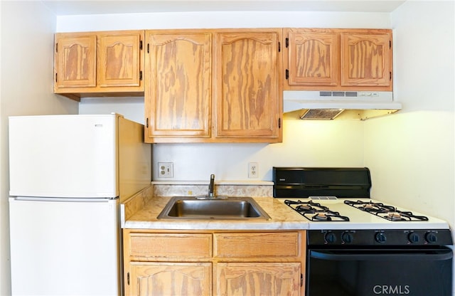 kitchen featuring white fridge, sink, light brown cabinetry, and gas stove