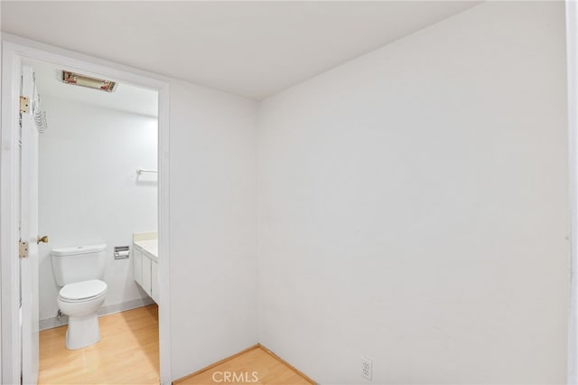 bathroom featuring vanity, wood-type flooring, and toilet