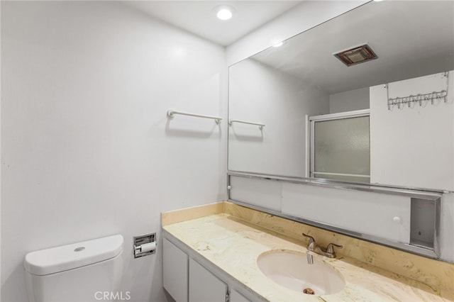 bathroom featuring vanity, toilet, and an enclosed shower