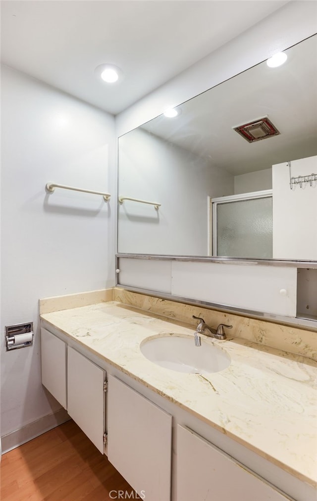 bathroom with vanity, hardwood / wood-style flooring, and an enclosed shower