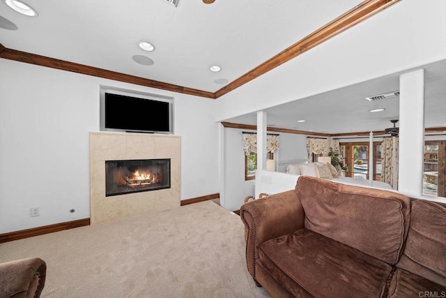 living room featuring a fireplace, carpet floors, ceiling fan, and crown molding