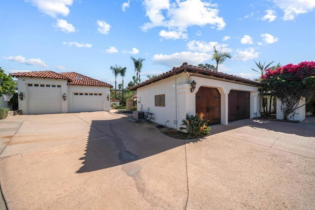 view of front of property with a garage and central air condition unit