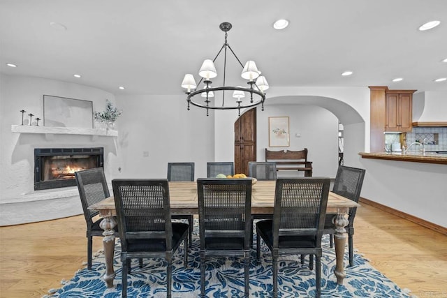 dining room with light wood-type flooring and a notable chandelier