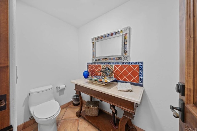 bathroom featuring tasteful backsplash, tile patterned flooring, and toilet