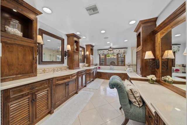 bathroom with tile patterned flooring, vanity, ceiling fan, and a bathtub