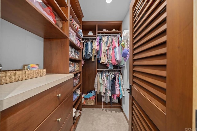 walk in closet with light colored carpet