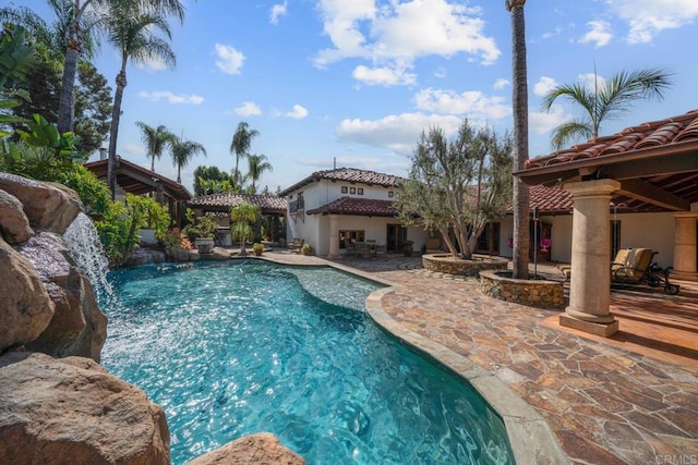 view of pool featuring pool water feature and a patio area