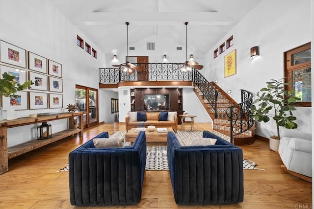 living room with beam ceiling, ceiling fan, hardwood / wood-style floors, and high vaulted ceiling