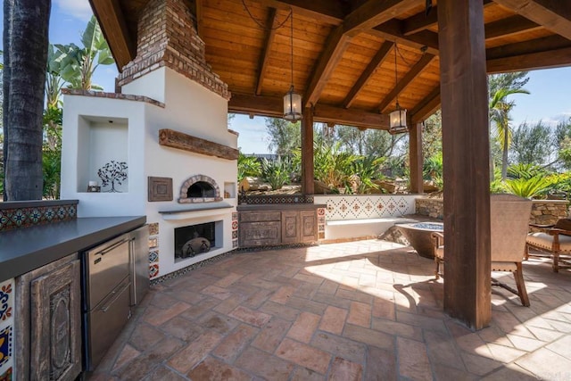 view of patio / terrace with a gazebo, an outdoor kitchen, and an outdoor fireplace