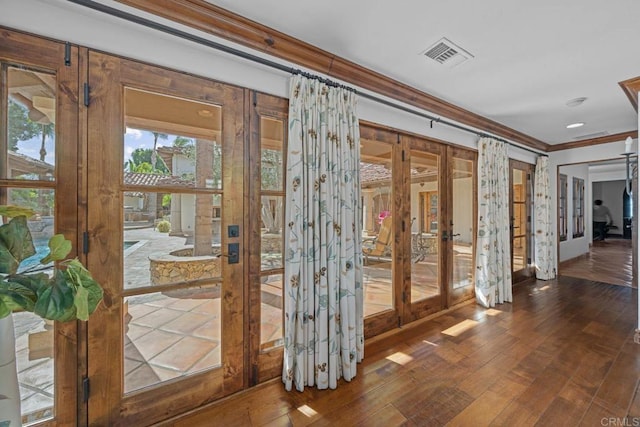 doorway featuring french doors, ornamental molding, and hardwood / wood-style floors