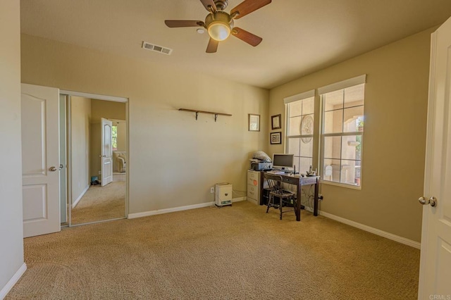 unfurnished office with ceiling fan and light colored carpet