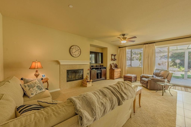 tiled living room with a tiled fireplace and ceiling fan