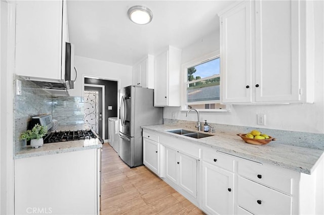 kitchen featuring white cabinets, light stone countertops, and sink