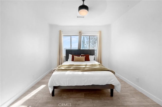 bedroom with ceiling fan and light hardwood / wood-style floors