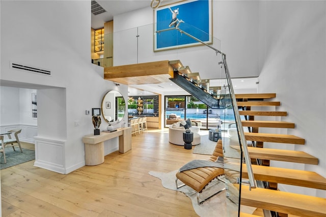 stairway featuring hardwood / wood-style flooring and a towering ceiling