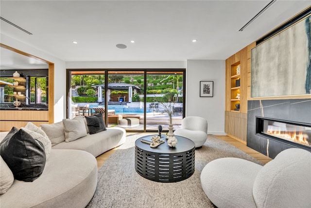 living room featuring built in shelves and light wood-type flooring