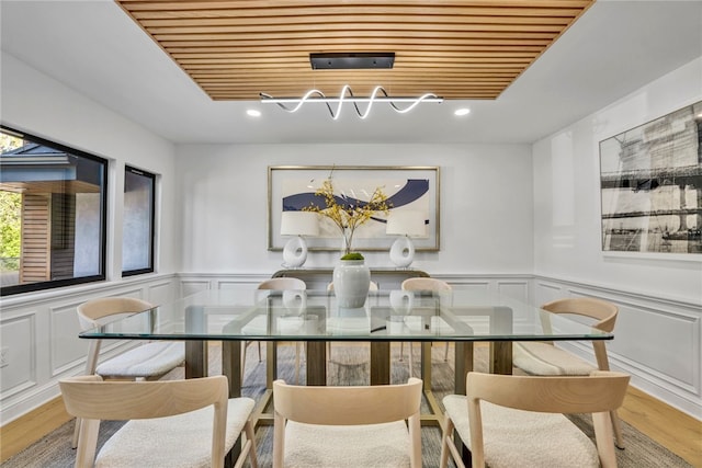 dining space featuring light hardwood / wood-style flooring and wooden ceiling