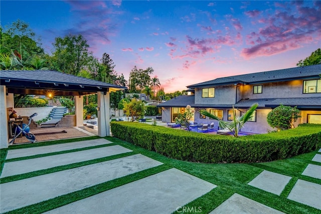 yard at dusk featuring a gazebo and a patio area