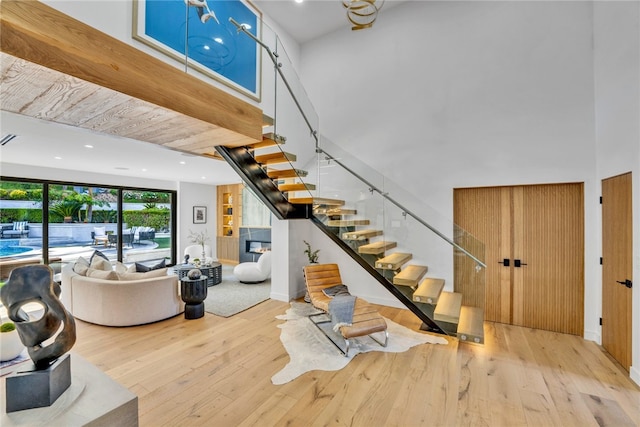 staircase with wood-type flooring and a high ceiling