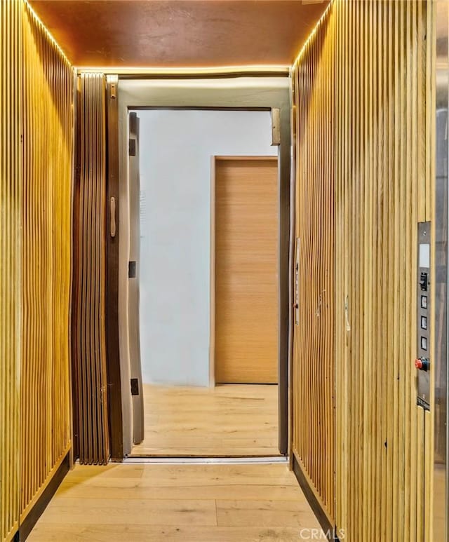 corridor with light hardwood / wood-style floors