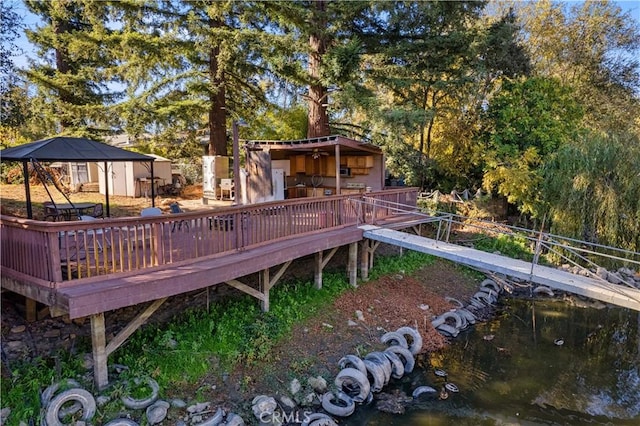 exterior space with a gazebo, a storage shed, and a deck with water view