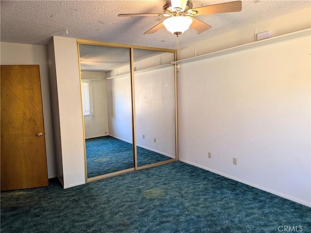 unfurnished bedroom featuring ceiling fan, a closet, dark carpet, and a textured ceiling