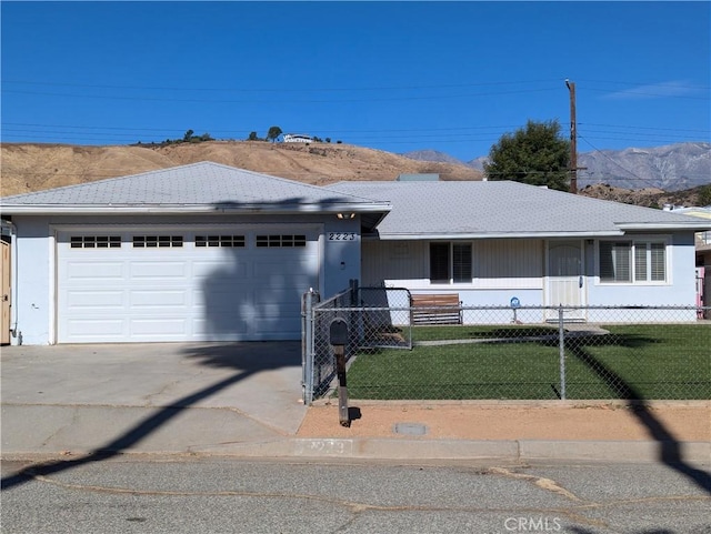 ranch-style house with a mountain view, a garage, and a front lawn