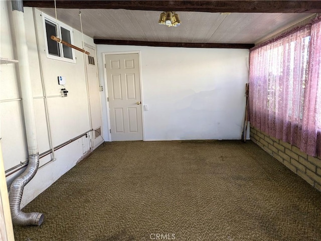 empty room featuring carpet, beamed ceiling, and wood ceiling