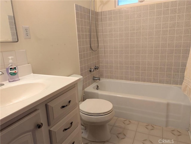 full bathroom with tile patterned floors, vanity, tiled shower / bath combo, and toilet