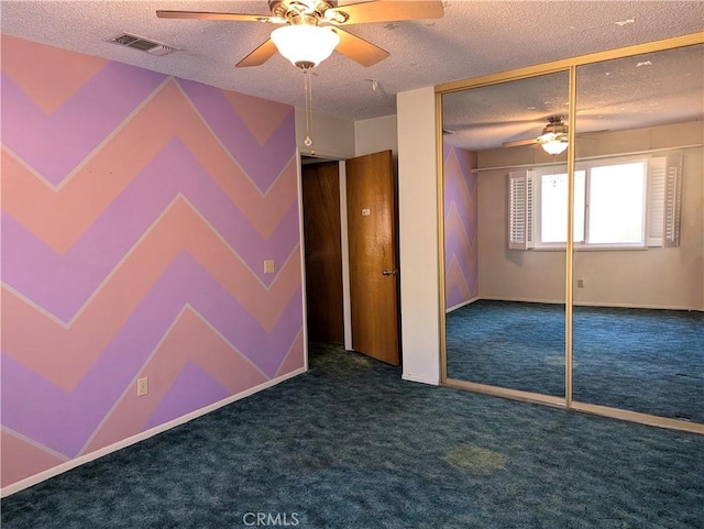 carpeted empty room with a textured ceiling and ceiling fan