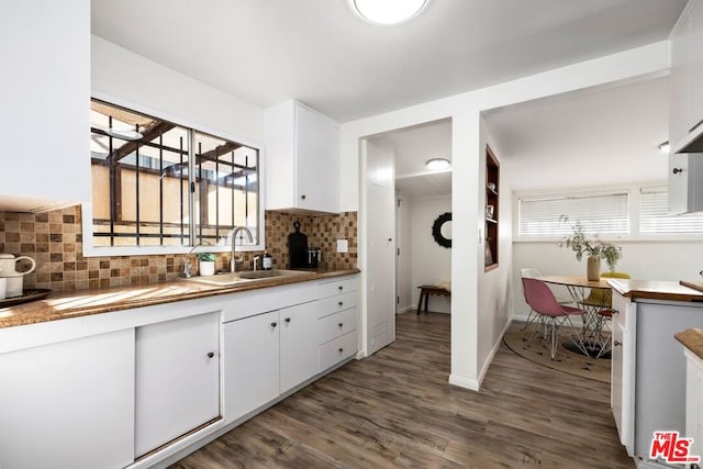 kitchen featuring dark hardwood / wood-style floors, backsplash, white cabinets, and sink