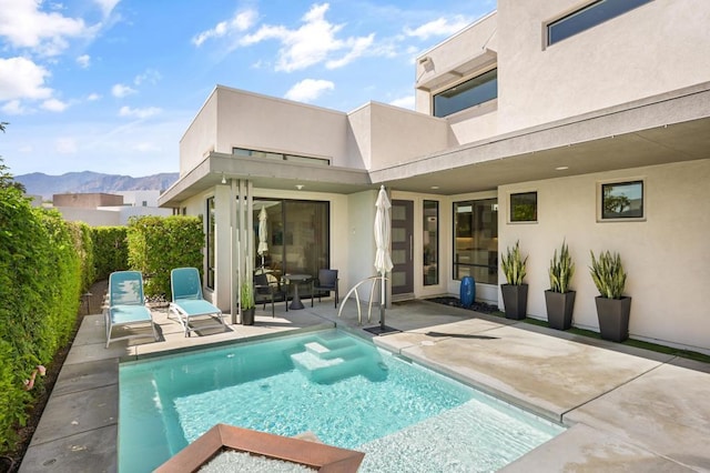 exterior space featuring a mountain view, a fenced in pool, and a patio area