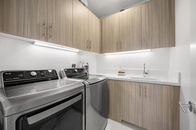 clothes washing area featuring separate washer and dryer, sink, light tile patterned flooring, and cabinets