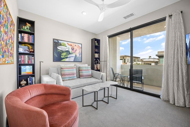 carpeted living room with ceiling fan