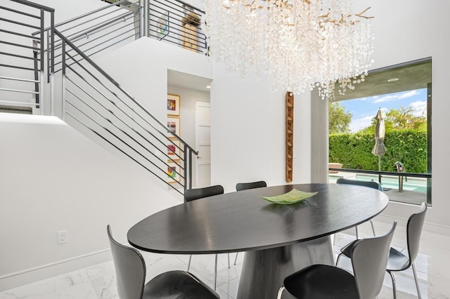 dining room with a towering ceiling and a chandelier