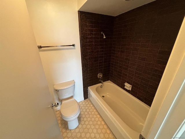 bathroom featuring toilet and tiled shower / bath