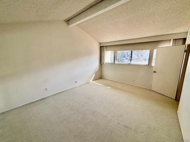 spare room with carpet flooring, a textured ceiling, and vaulted ceiling with beams