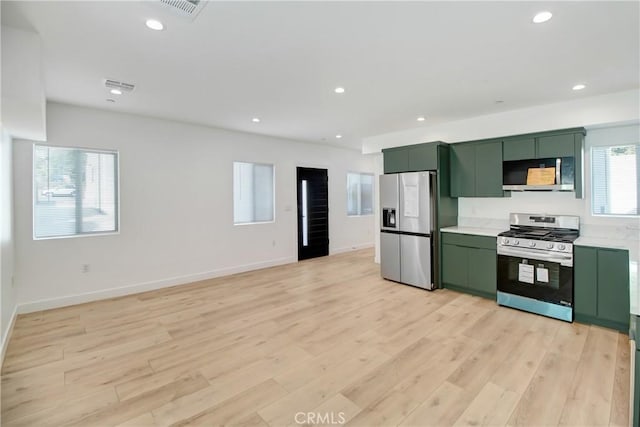 kitchen with light hardwood / wood-style floors, appliances with stainless steel finishes, and green cabinetry