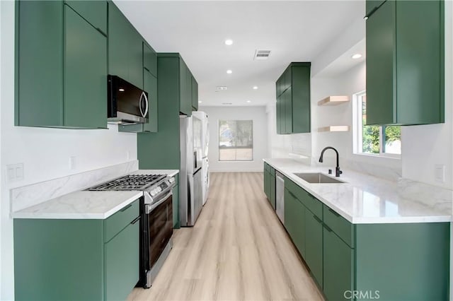 kitchen featuring sink, stainless steel appliances, and green cabinetry