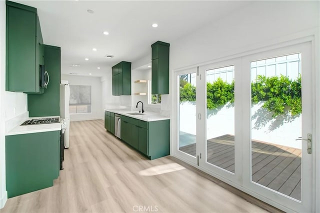 kitchen with light hardwood / wood-style floors, sink, green cabinets, black dishwasher, and white refrigerator