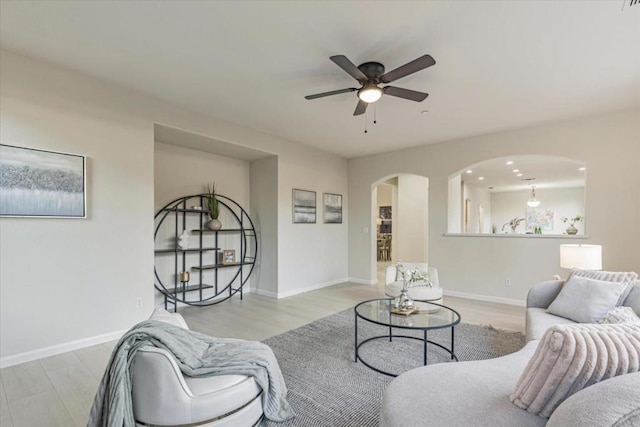 living room with ceiling fan and light hardwood / wood-style flooring